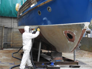 Old antifoul removal from a hull ready for a new coppercoat
